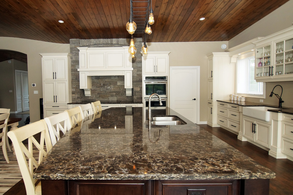 Inspiration for a large rustic galley kitchen remodel with an undermount sink, recessed-panel cabinets, white cabinets, quartzite countertops, stainless steel appliances and brown countertops