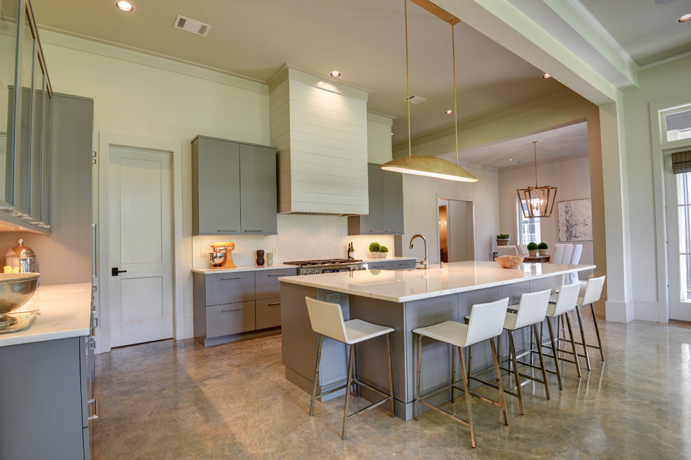 Example of a mid-sized transitional l-shaped open concept kitchen design in New Orleans with a farmhouse sink, flat-panel cabinets, gray cabinets, paneled appliances and an island