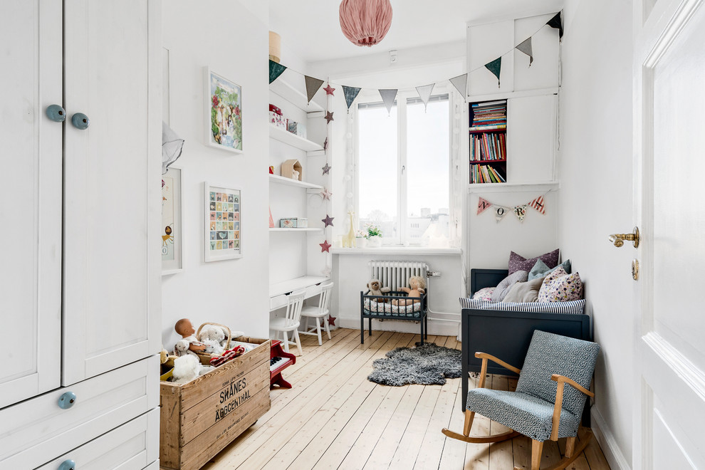 Scandinavian kids' room in Copenhagen with white walls, light hardwood floors and beige floor.