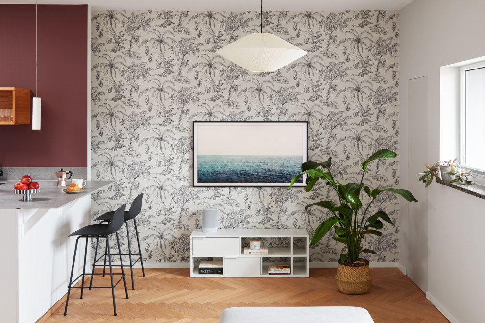 На фото: маленькая открытая, серо-белая гостиная комната в современном стиле с серыми стенами, светлым паркетным полом и телевизором на стене для на участке и в саду с