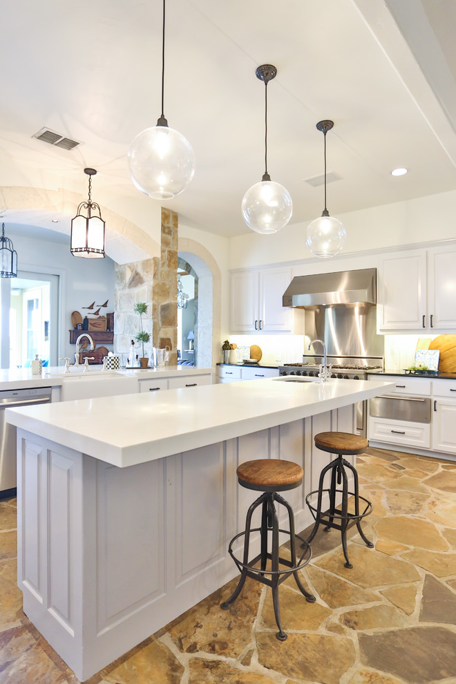 Design ideas for a large traditional u-shaped eat-in kitchen in Austin with a farmhouse sink, raised-panel cabinets, white cabinets, glass benchtops, white splashback, marble splashback, stainless steel appliances, limestone floors, with island, brown floor and yellow benchtop.