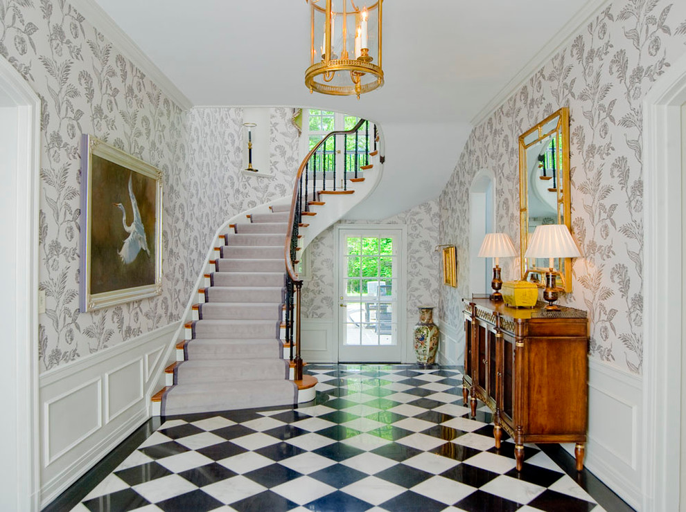 This is an example of a traditional foyer in Baltimore with white walls, a single front door, a glass front door, marble floors and multi-coloured floor.
