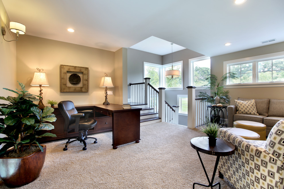 Photo of a large transitional study room in Grand Rapids with beige walls, carpet, no fireplace and a freestanding desk.