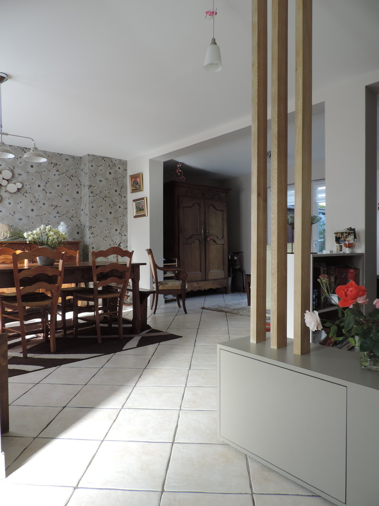 Exemple d'une salle de séjour moderne de taille moyenne et ouverte avec un mur beige, un sol en carrelage de céramique, un téléviseur dissimulé et un sol beige.