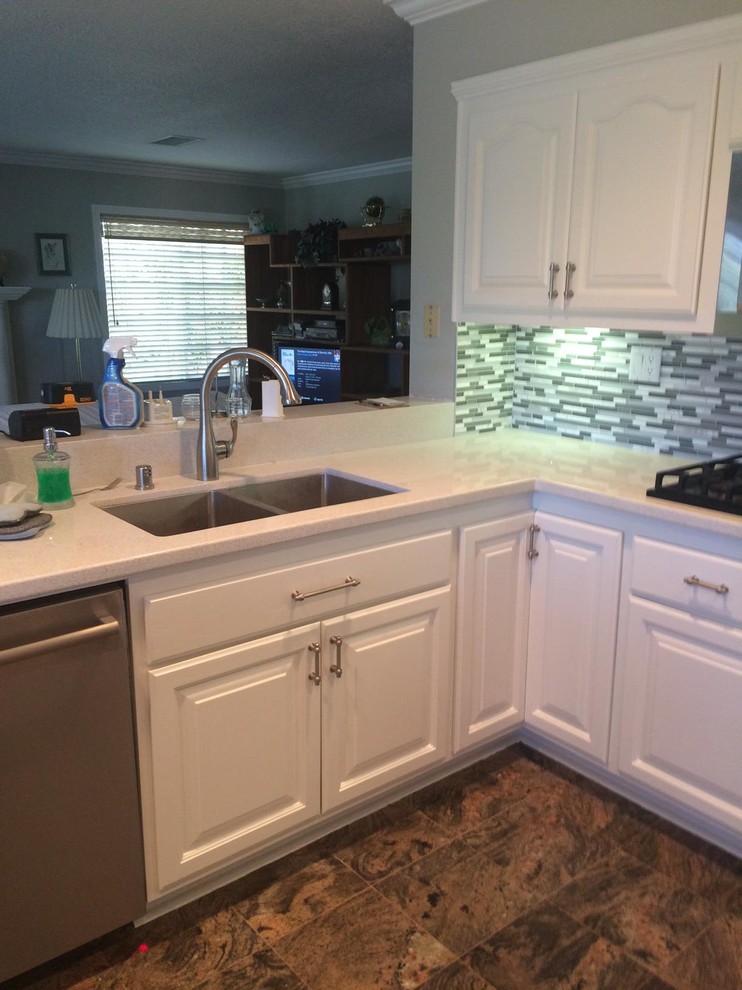 Foto di una cucina ad U design di medie dimensioni con lavello a doppia vasca, ante con bugna sagomata, ante bianche, top in quarzite, paraspruzzi multicolore e paraspruzzi con piastrelle di vetro