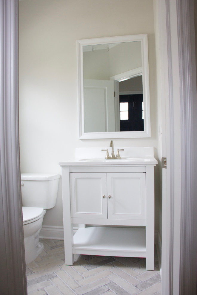Small country powder room in Detroit with recessed-panel cabinets, white cabinets, white walls, porcelain floors, solid surface benchtops, white floor, white benchtops and a freestanding vanity.