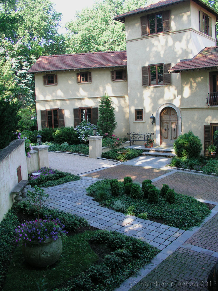 Large mediterranean courtyard shaded formal garden in New York with brick pavers.