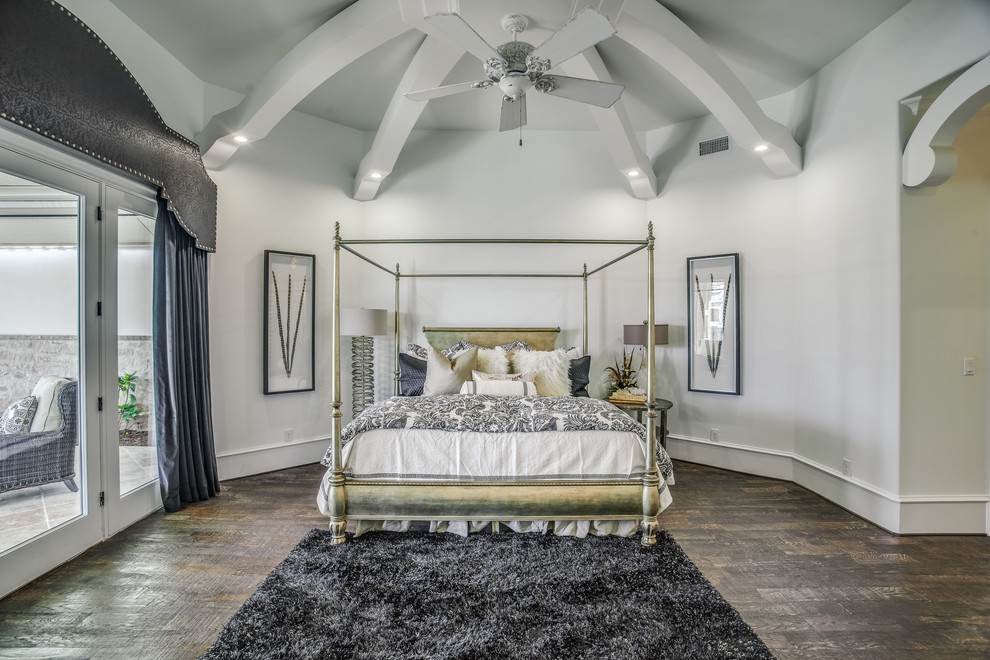 Photo of a large traditional master bedroom in Austin with dark hardwood floors and white walls.