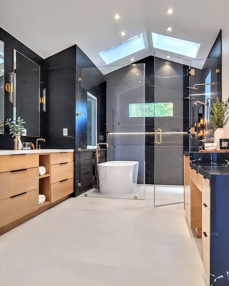 Inspiration for a mid-sized modern master wet room bathroom in Los Angeles with flat-panel cabinets, light wood cabinets, a freestanding tub, black tile, porcelain tile, black walls, porcelain floors, engineered quartz benchtops, beige floor, a hinged shower door, white benchtops, a double vanity and a built-in vanity.