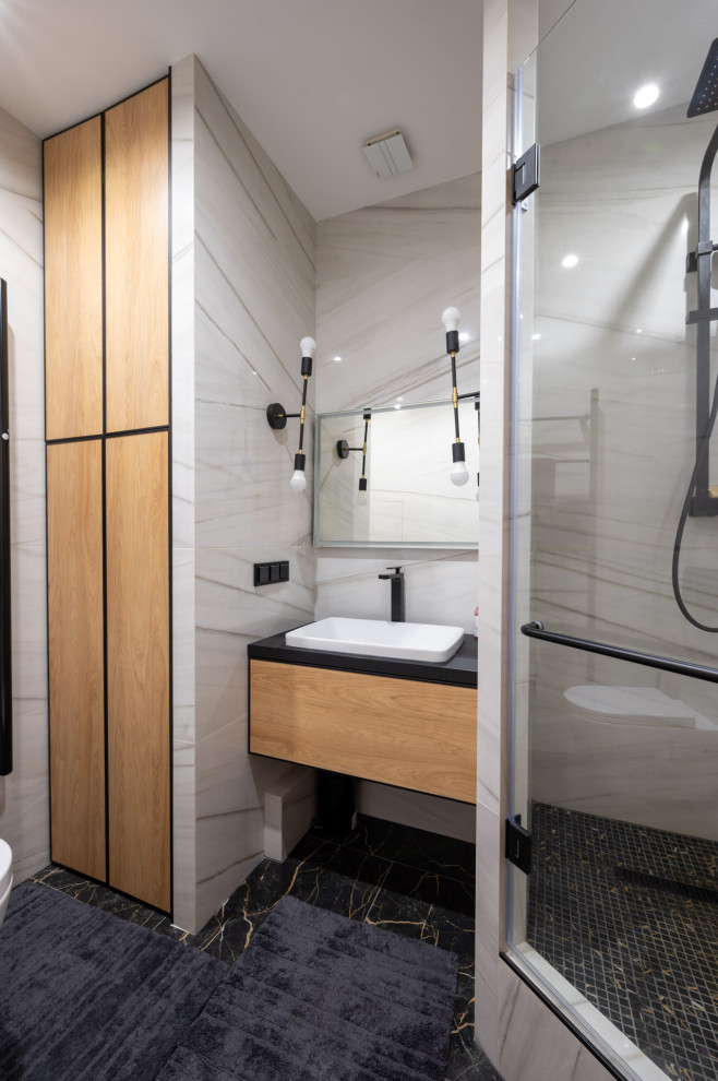 サンクトペテルブルクにあるコンテンポラリースタイルのおしゃれなバスルーム (浴槽なし) (コーナー設置型シャワー、開き戸のシャワー、黒い洗面カウンター、洗面台1つ) の写真