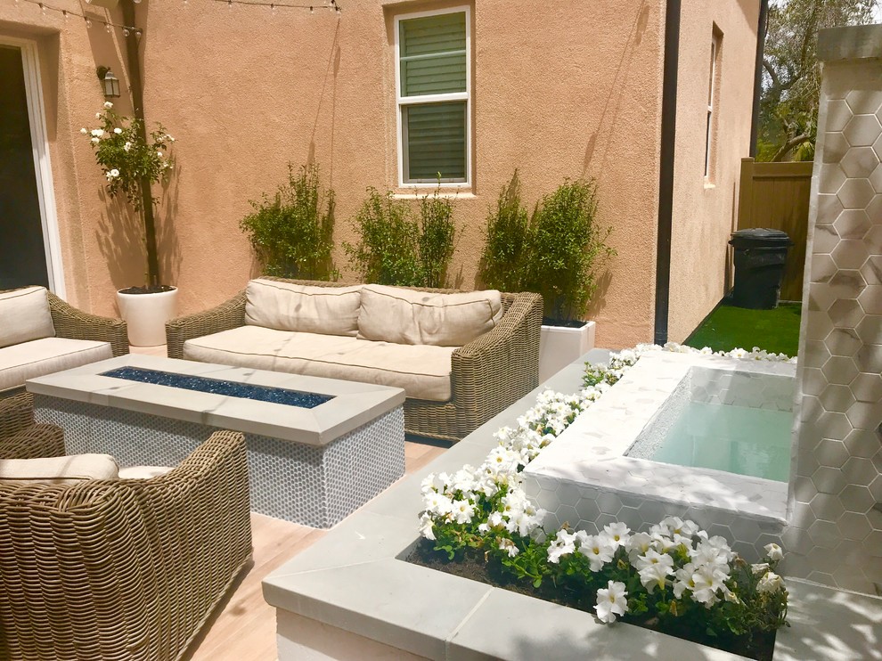 Mid-sized contemporary backyard patio in San Diego with a water feature, decking and no cover.