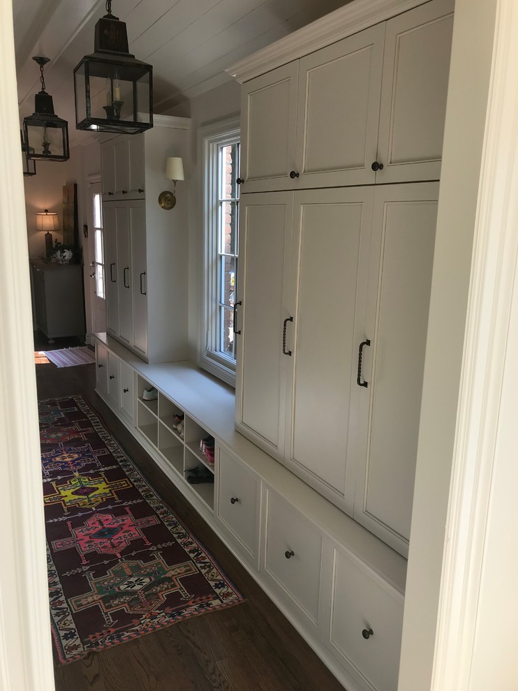 Mid-sized transitional dark wood floor and brown floor mudroom photo with white walls and a white front door