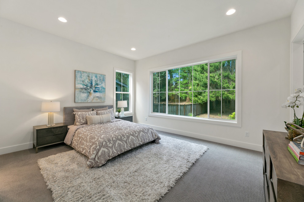 This is an example of a large farmhouse guest bedroom in Seattle with white walls, carpet and grey floors.