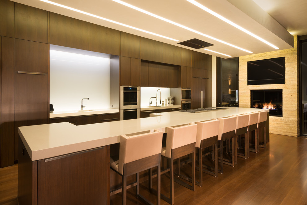 Photo of a large contemporary galley eat-in kitchen in Denver with flat-panel cabinets, dark wood cabinets, multi-coloured splashback, glass sheet splashback and with island.