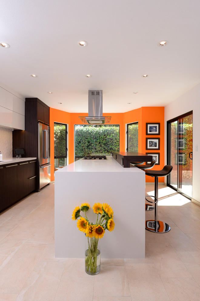 Mid-sized contemporary galley eat-in kitchen in Orange County with flat-panel cabinets, dark wood cabinets, quartz benchtops, white splashback, ceramic splashback, stainless steel appliances, porcelain floors and with island.