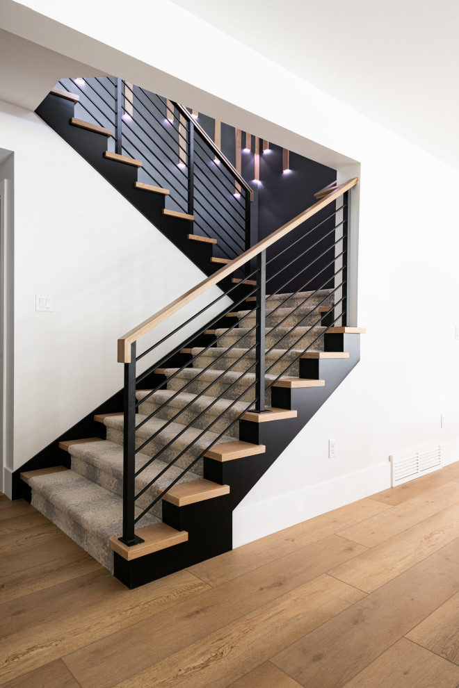 Geräumige Moderne Treppe in U-Form mit Teppich-Treppenstufen, Teppich-Setzstufen, Stahlgeländer und Wandpaneelen in Salt Lake City