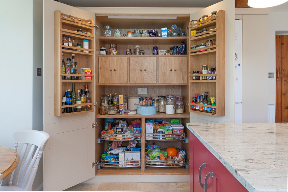Inspiration for a large traditional kitchen pantry in Kent with red cabinets, granite benchtops, panelled appliances, porcelain floors and with island.