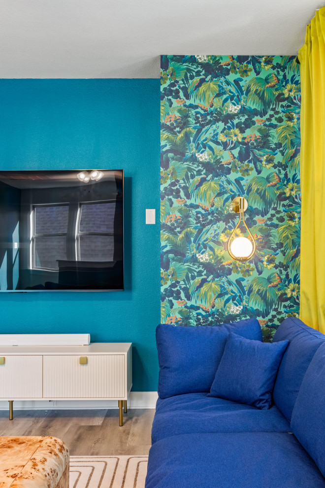 Modelo de sala de estar actual grande con paredes multicolor, suelo laminado, televisor colgado en la pared y papel pintado