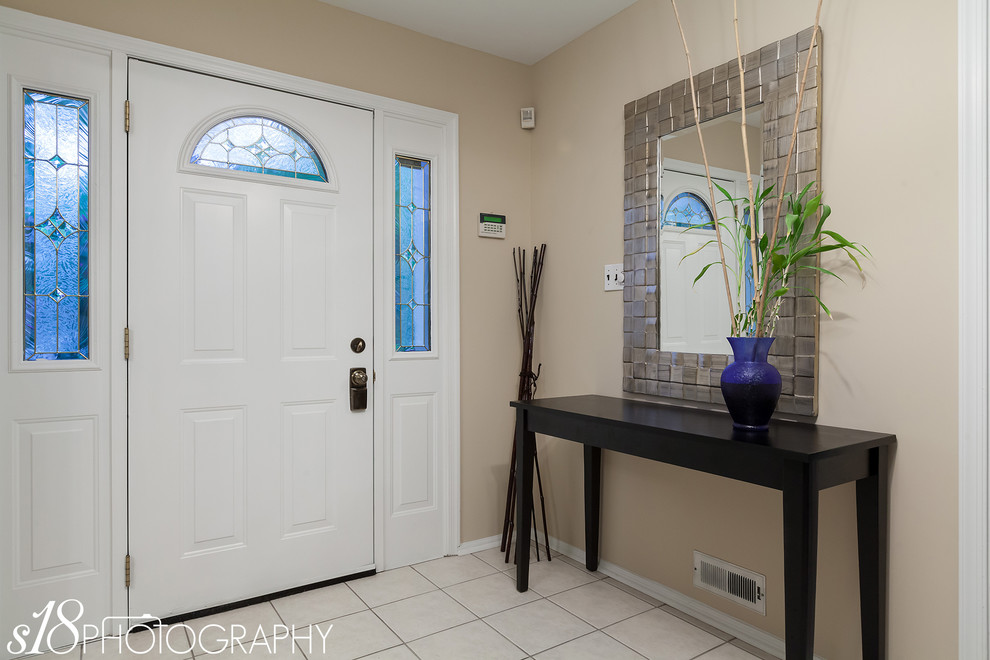 This is an example of a small contemporary foyer in Philadelphia with beige walls and ceramic floors.