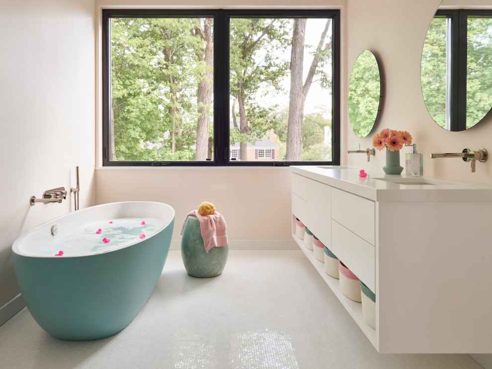 На фото: детская ванная комната в современном стиле с белыми фасадами, отдельно стоящей ванной, двойным душем, унитазом-моноблоком, розовой плиткой, плиткой мозаикой, розовыми стенами, полом из мозаичной плитки, врезной раковиной, столешницей из искусственного кварца, белым полом, душем с распашными дверями, белой столешницей, тумбой под две раковины и подвесной тумбой с