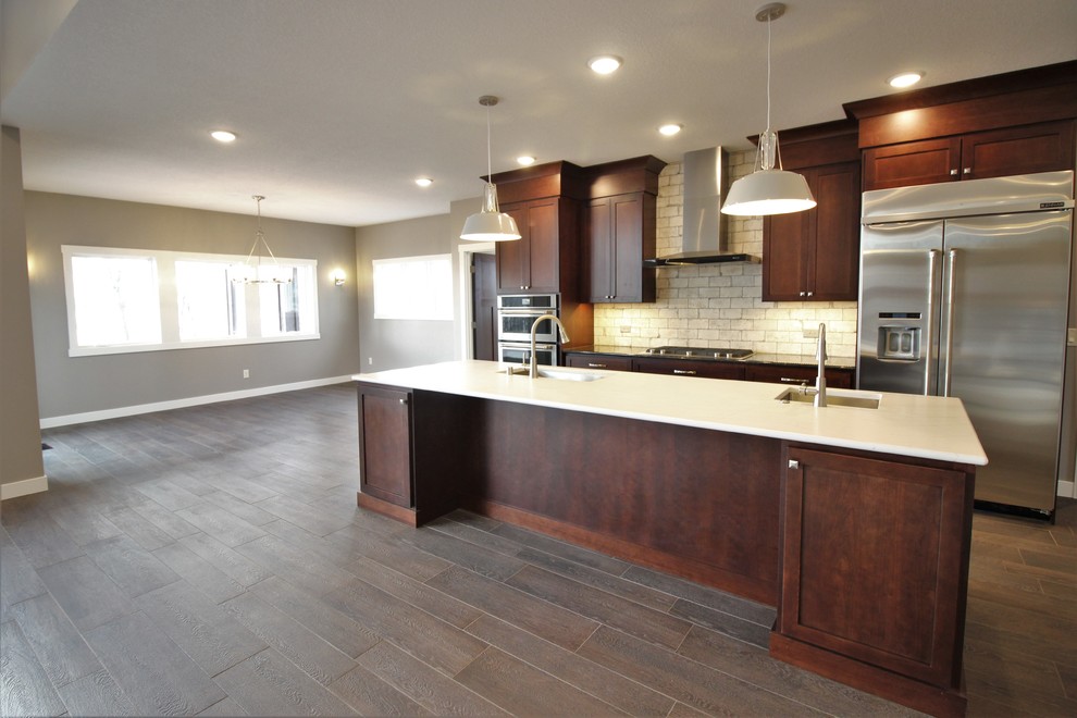This is an example of a mid-sized arts and crafts galley eat-in kitchen in Minneapolis with an undermount sink, shaker cabinets, medium wood cabinets, stainless steel appliances, porcelain floors, with island and brown floor.