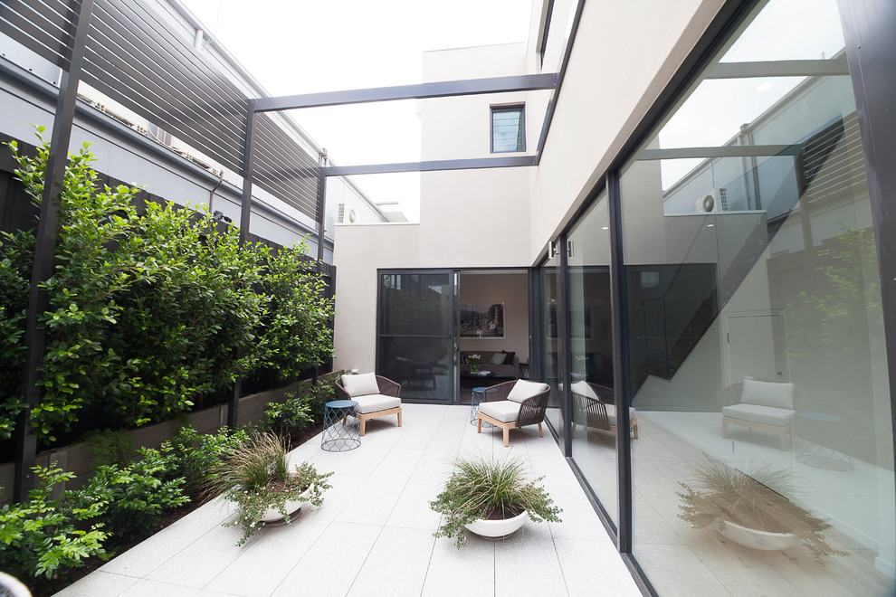 Inspiration for a mid-sized contemporary courtyard patio in Melbourne with no cover and tile.