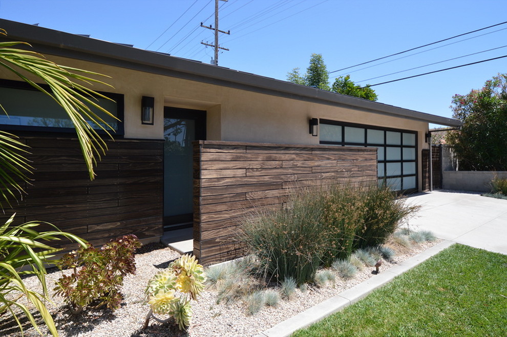 Design ideas for a large midcentury one-storey stucco beige exterior in Los Angeles.