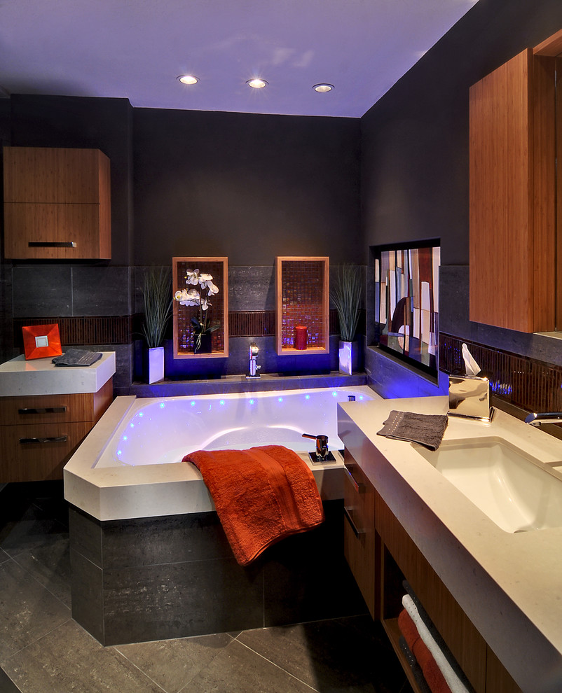 Design ideas for a small contemporary master bathroom in Phoenix with an undermount sink, flat-panel cabinets, light wood cabinets, engineered quartz benchtops, a drop-in tub, an alcove shower, a one-piece toilet, gray tile, porcelain tile, grey walls and porcelain floors.