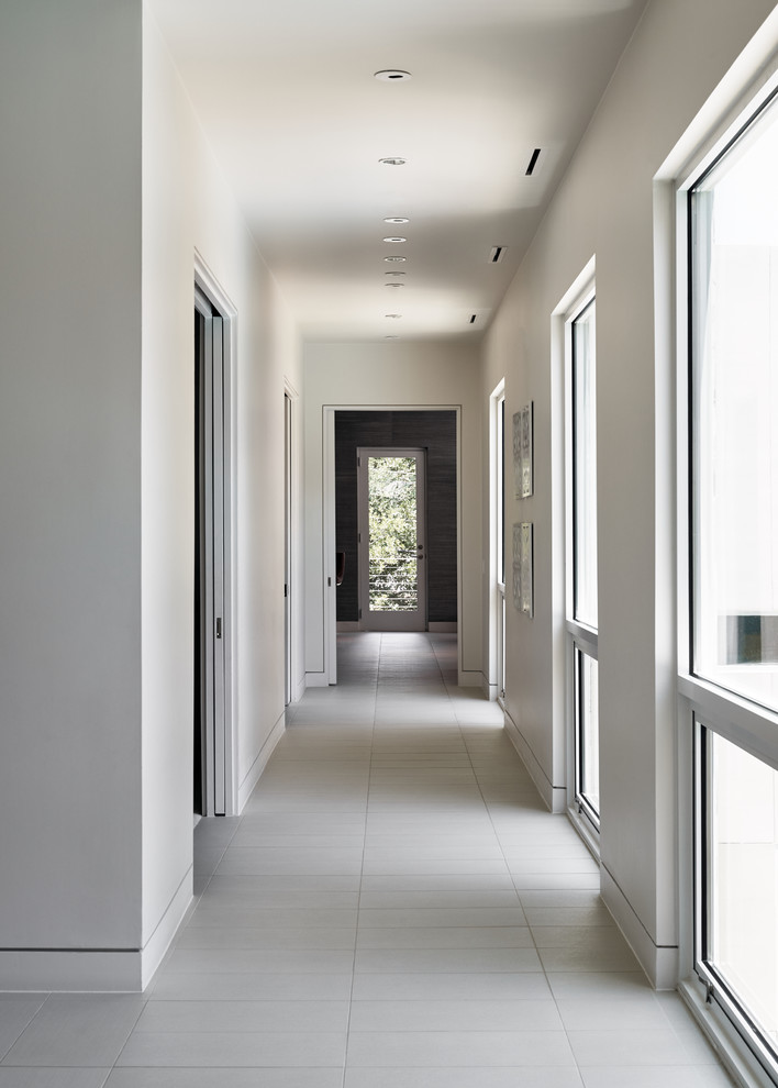 Photo of a mid-sized contemporary hallway in Dallas with white walls, porcelain floors and white floor.
