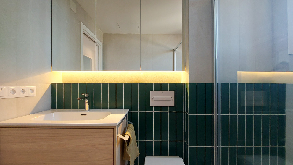 Стильный дизайн: ванная комната среднего размера, в белых тонах с отделкой деревом в стиле модернизм с плоскими фасадами, светлыми деревянными фасадами, инсталляцией, зеленой плиткой, керамической плиткой, зелеными стенами, полом из керамической плитки, монолитной раковиной, серым полом, белой столешницей, зеркалом с подсветкой, тумбой под одну раковину и подвесной тумбой - последний тренд