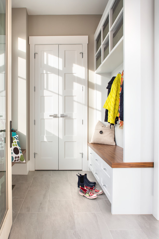 Design ideas for a mid-sized transitional mudroom in Calgary with beige walls and porcelain floors.