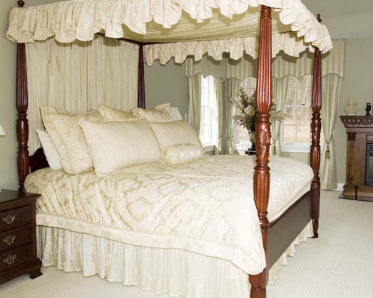 На фото: большая хозяйская спальня в классическом стиле с зелеными стенами, ковровым покрытием, стандартным камином, фасадом камина из дерева и белым полом с