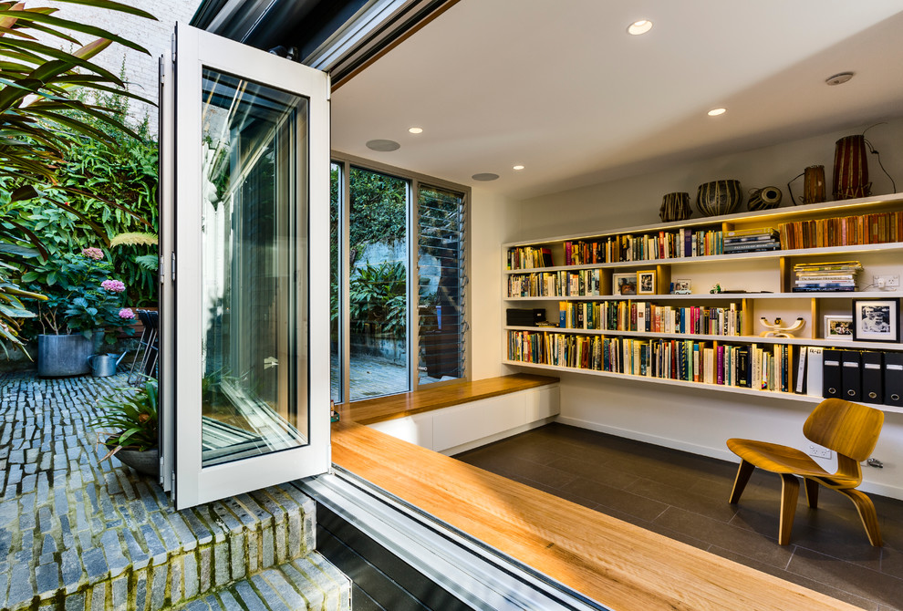 Mid-sized contemporary open concept living room in Sydney with a library, white walls, ceramic floors and grey floor.