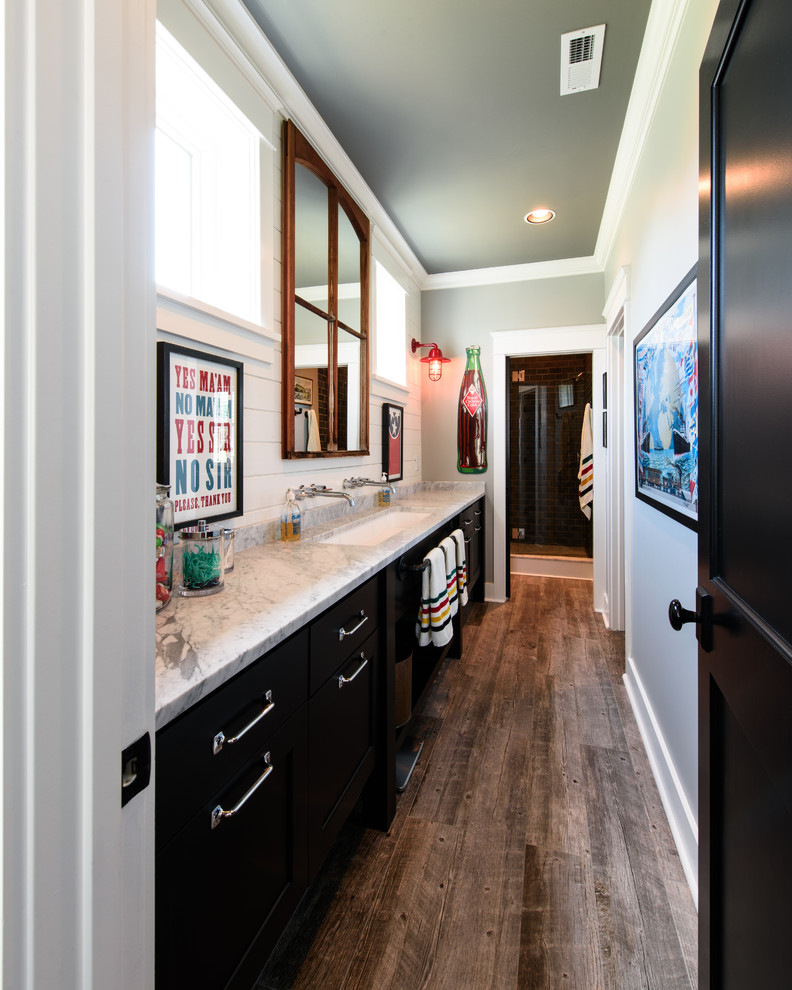 Transitional bathroom in Nashville with shaker cabinets, black cabinets, medium hardwood floors, a trough sink and marble benchtops.