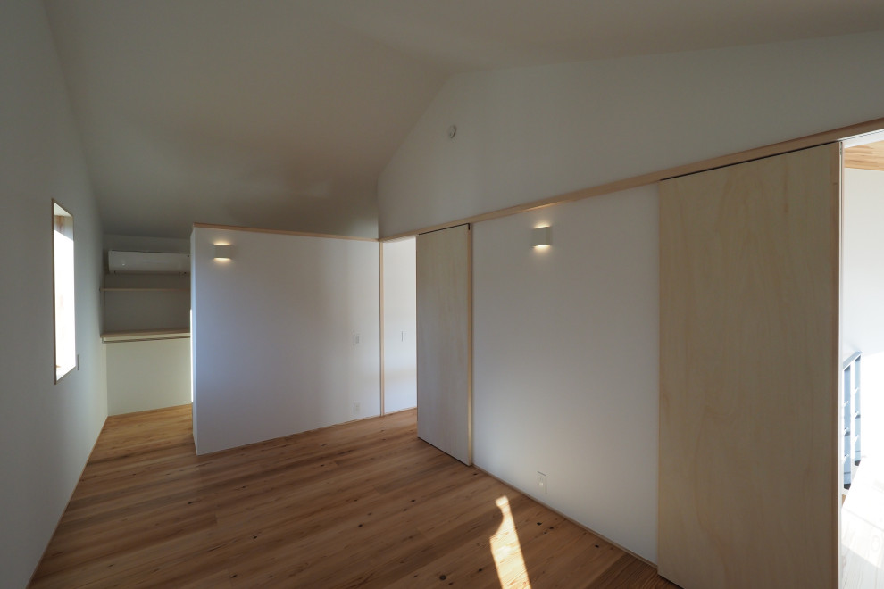 Ejemplo de dormitorio de estilo americano con suelo de madera clara y madera