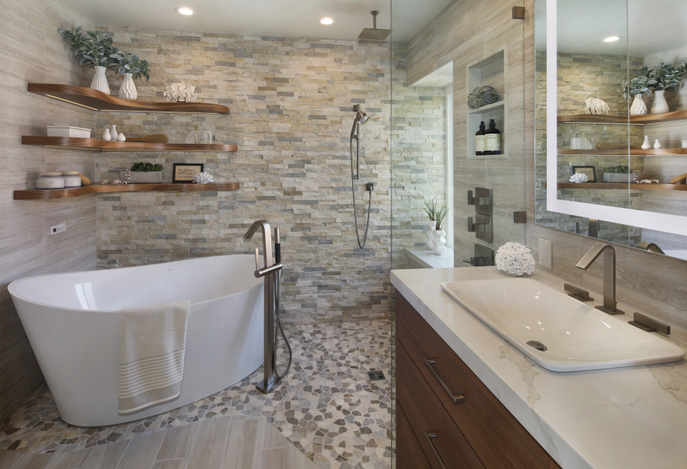 Inspiration for a contemporary master bathroom in Orange County with flat-panel cabinets, medium wood cabinets, a freestanding tub, a curbless shower, beige tile, porcelain tile, beige walls, pebble tile floors, a vessel sink, engineered quartz benchtops, multi-coloured floor, an open shower, beige benchtops, a double vanity and a built-in vanity.