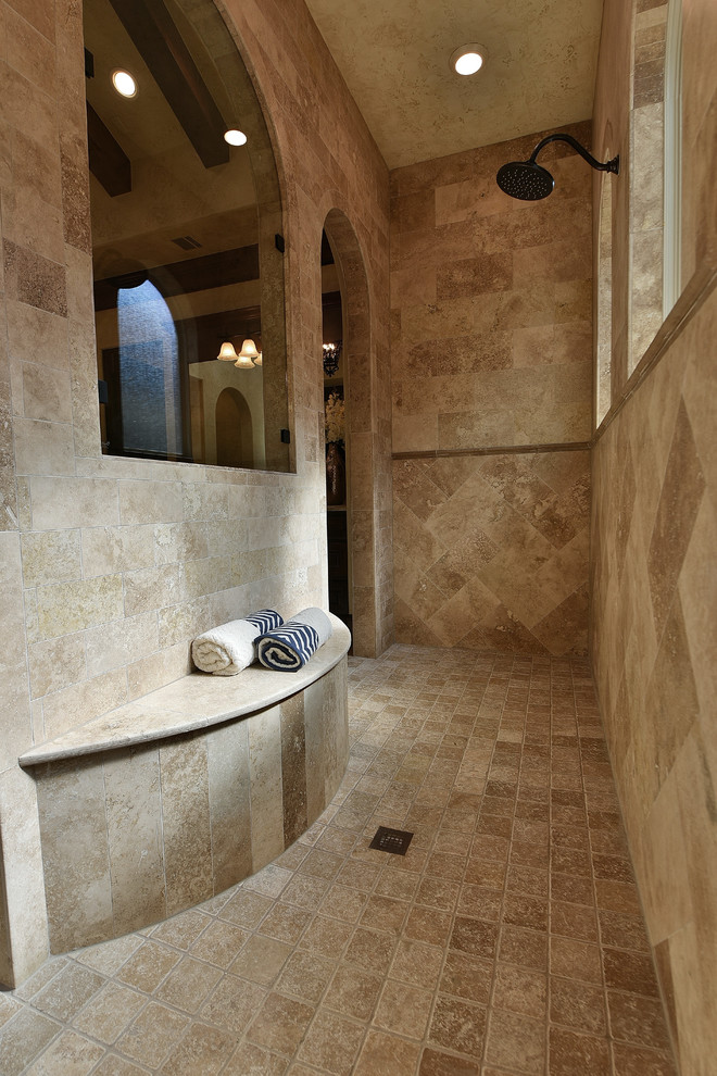 Inspiration for a large mediterranean master bathroom in Houston with raised-panel cabinets, medium wood cabinets, a freestanding tub, a double shower, beige tile, ceramic tile, beige walls, travertine floors, an undermount sink, marble benchtops, beige floor and an open shower.