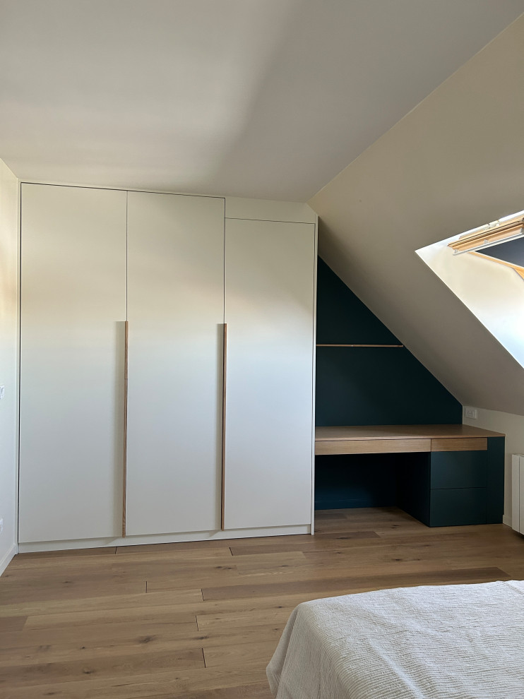 Foto di un armadio o armadio a muro unisex minimalista di medie dimensioni con parquet chiaro, pavimento marrone, ante a filo e ante bianche