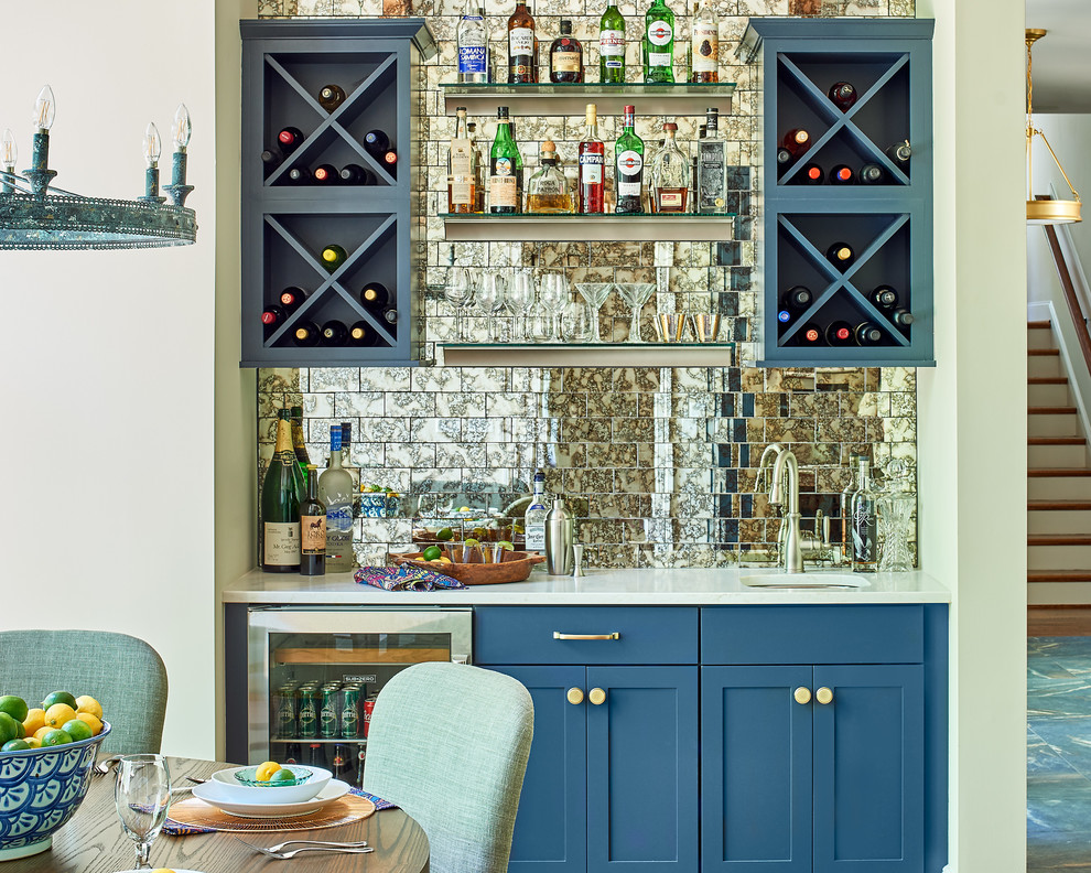 This is an example of a transitional wet bar in Raleigh with an undermount sink, shaker cabinets, blue cabinets, mirror splashback and white benchtop.