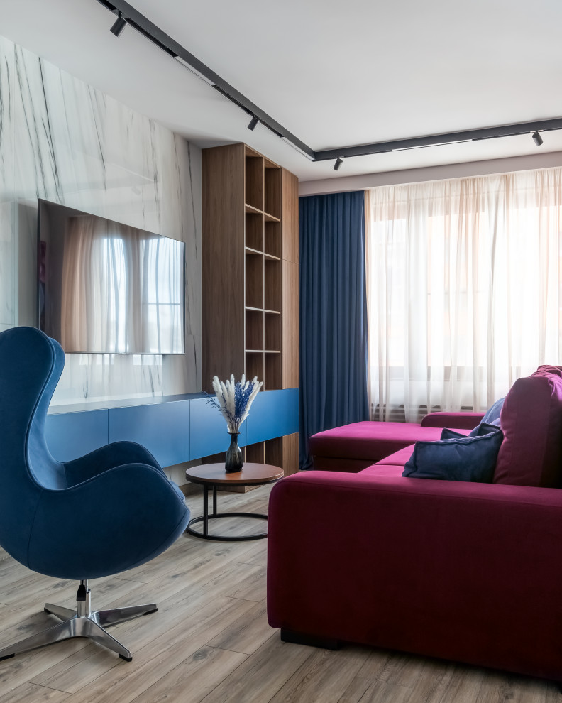 Свежая идея для дизайна: гостиная комната среднего размера в современном стиле с бежевыми стенами, полом из ламината, телевизором на стене, зоной отдыха, коричневым полом и бордовым диваном - отличное фото интерьера