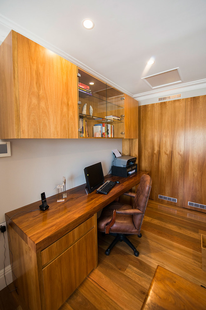 Large traditional study room in Sydney with brown walls, no fireplace, a built-in desk and travertine floors.
