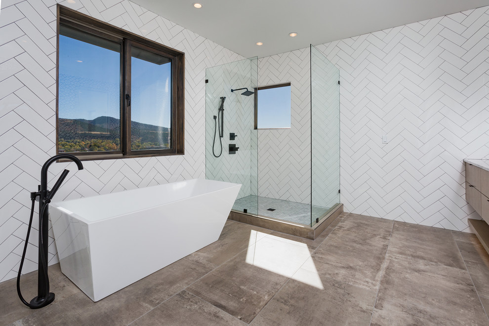 This is an example of a large contemporary master bathroom in Albuquerque with medium wood cabinets, a freestanding tub, an open shower, white tile, subway tile, white walls, cement tiles, an undermount sink, marble benchtops, grey floor and an open shower.