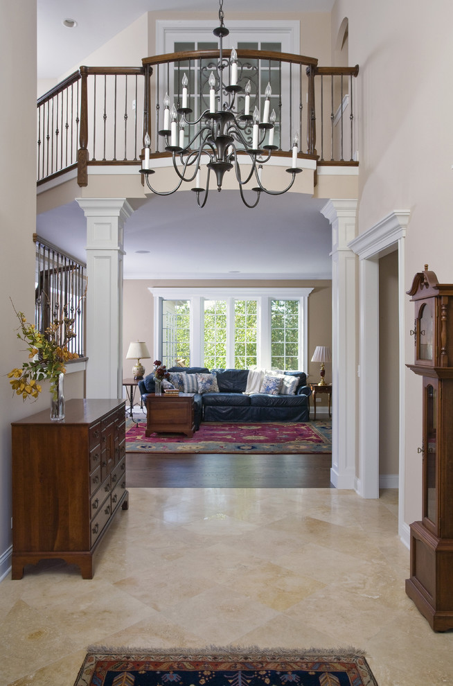 Inspiration for a large traditional foyer in Chicago with beige walls, limestone floors, a double front door, a dark wood front door and beige floor.