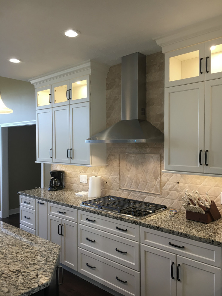 Large transitional u-shaped dark wood floor and brown floor eat-in kitchen photo with an undermount sink, shaker cabinets, white cabinets, granite countertops, white backsplash, terra-cotta backsplash, stainless steel appliances, an island and multicolored countertops