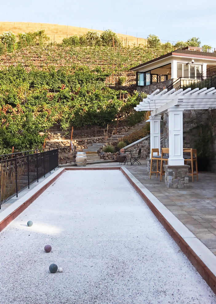 Traditional sloped outdoor sport court in San Francisco with natural stone pavers and a metal fence.