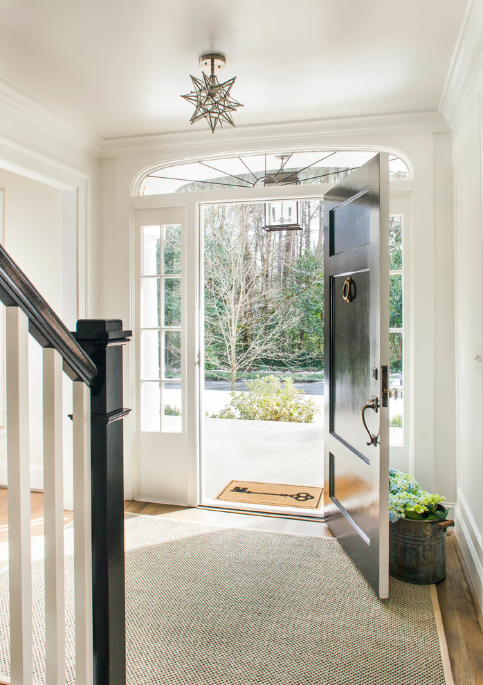 Photo of a mid-sized transitional foyer in Atlanta with white walls, medium hardwood floors, a single front door and a black front door.