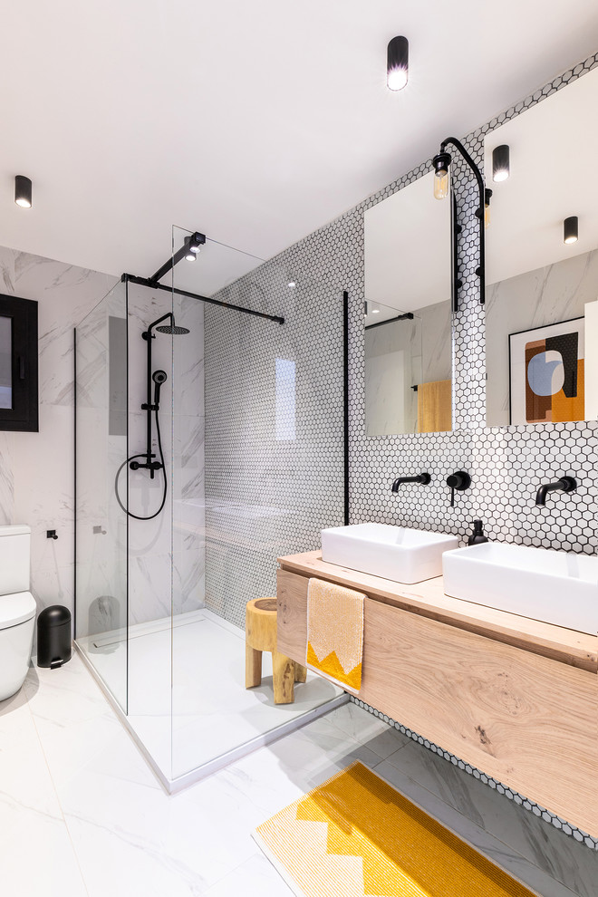 Photo of a mid-sized contemporary master bathroom in Other with flat-panel cabinets, light wood cabinets, an open shower, white tile, mosaic tile, a vessel sink, wood benchtops, grey floor, an open shower and beige benchtops.