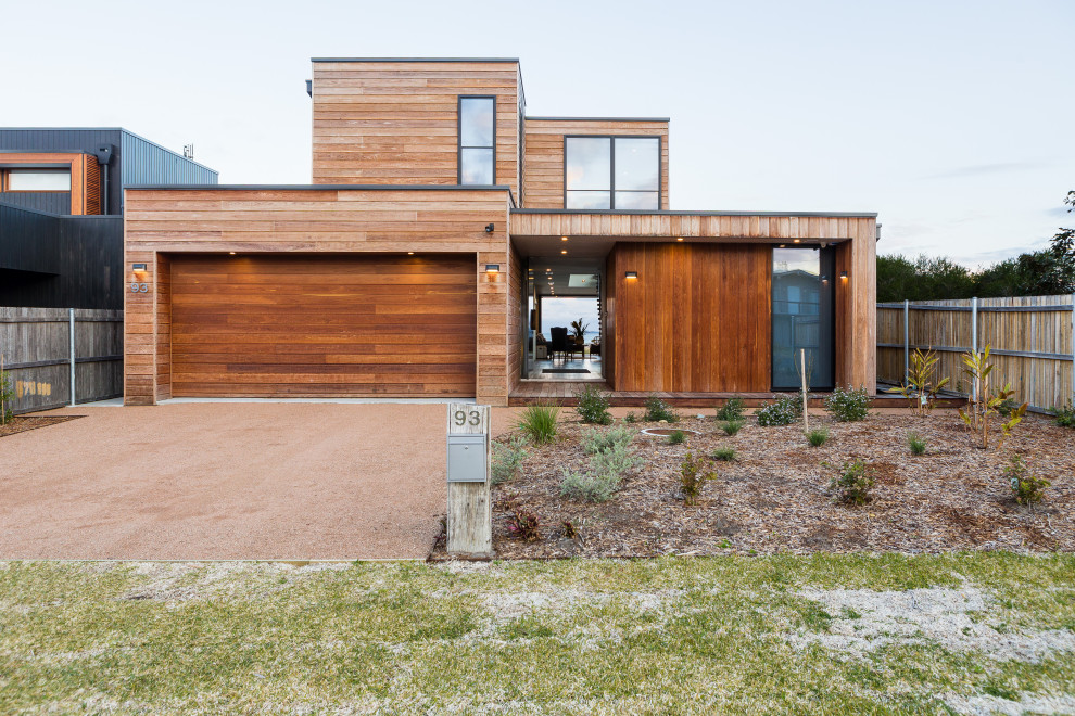 This is an example of a contemporary two-storey brown house exterior in Other with wood siding and a flat roof.