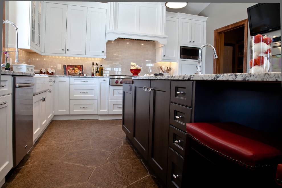 Example of a large transitional u-shaped slate floor and brown floor open concept kitchen design with a farmhouse sink, shaker cabinets, white cabinets, granite countertops, yellow backsplash, subway tile backsplash, stainless steel appliances and two islands