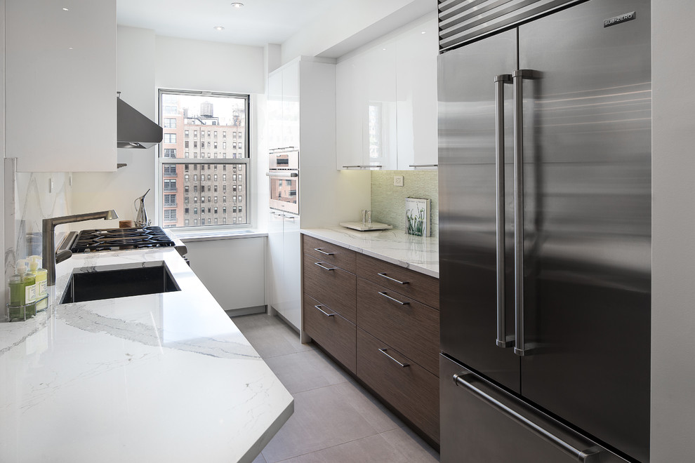 Photo of a mid-sized contemporary u-shaped open plan kitchen in New York with an undermount sink, flat-panel cabinets, dark wood cabinets, quartz benchtops, white splashback, stone slab splashback, stainless steel appliances, ceramic floors, multiple islands, grey floor and white benchtop.